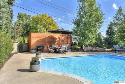 Private backyard oasis featuring a sparkling swimming pool with stylish outdoor lounge area and mature landscaping for ultimate relaxation.