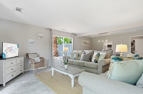 Relax in your beautifully furnished living room with coastal-inspired decor, comfortable seating, and entertainment center for perfect vacation evenings.