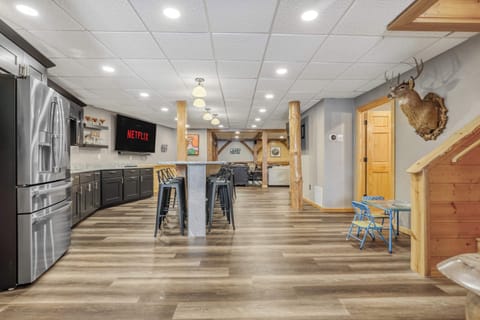 Our lower level is highlighted by a massive wet bar with 12 barstools, perfect for entertaining. We have three 85" smart TV's, 22ft shuffleboard table, darts, large gathering area, 1/2 bathroom, and walk out access to the exterior amenities.