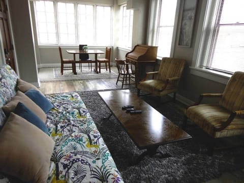 Here is the living room from kitchen hallway with sun room in the background.  The front door is just past the futon on the left.