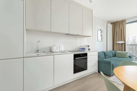Bright cooking space with white cabinets and built-in oven.