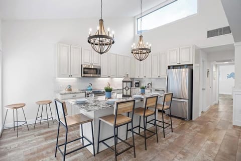 Dining area w/ modern lighting, ideal for meals and easy conversation.