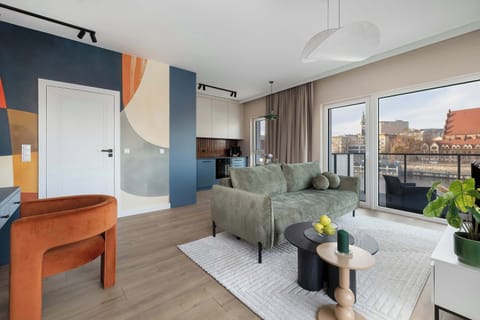 The open living area with its harmonious color palette offers a calming space where it’s easy to unwind after a busy day.