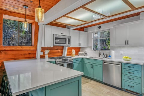 Kitchen: Drip coffee maker, blender, kettle, waffle maker, cooking utensils, tableware