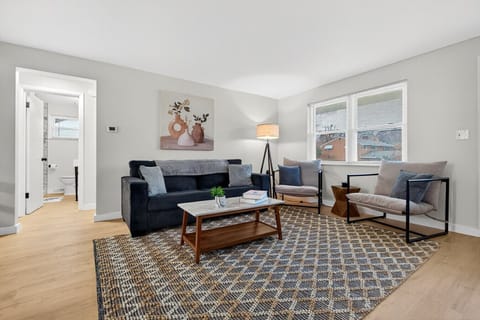 Living room with sofa seating, Smart TV, large windows, and plenty of natural light.