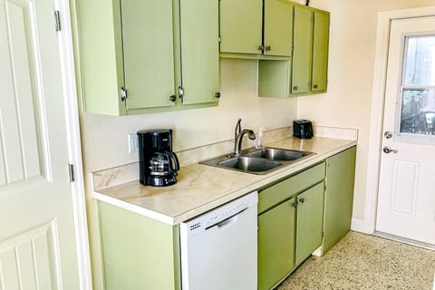 This charming kitchen offers all the essentials for a comfortable beach stay, featuring coastal cabinetry and modern conveniences. Perfect for preparing meals and snacks before heading out to enjoy the beach.