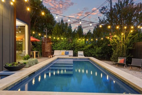 The heated pool glows beautifully under twinkling string lights, perfect for evening relaxation.