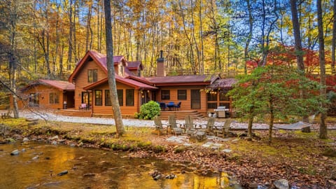 The cabin sits peacefully beside the flowing creek, surrounded by glowing fall colors and towering trees. Nature wraps around you from every angle. Enjoy the perfect mountain scene: a cozy cabin, a quiet hammock, and the calming sound of the creek.