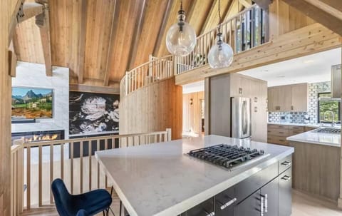 Dining area with bar stools, chef-style stove for entertaining. 