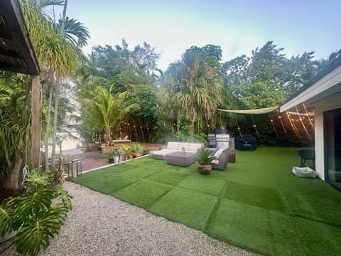 Private outdoor retreat featuring green turf and high privacy hedges.