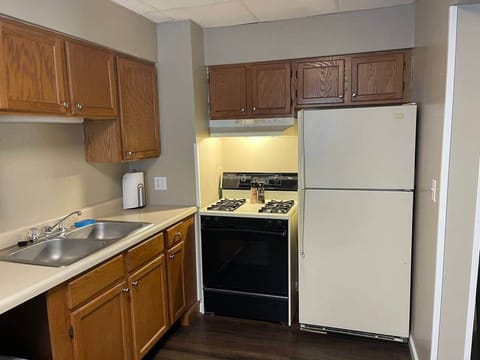 Small kitchen with fridge, stove, coffee maker, pots and skillets and utensils. 