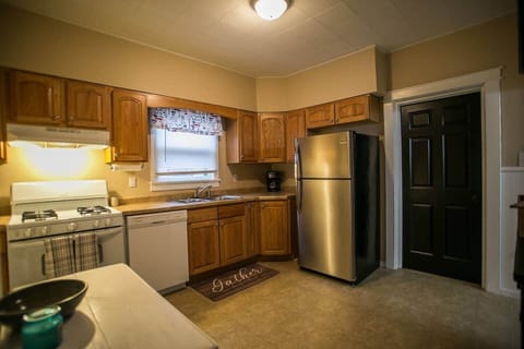 Kitchen with stove, oven, dishwasher, coffee and tea nook, refrigerator, and cooking supplies