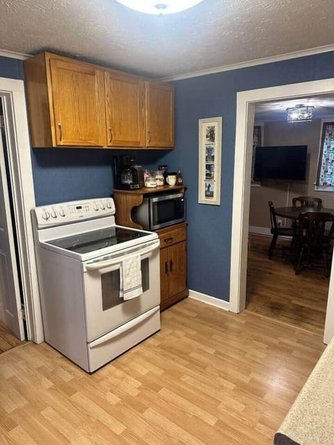 Kitchen with stove, coffee maker, microwave and cooking supplies