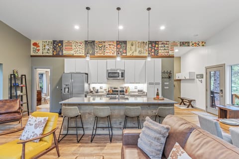 Modern kitchen with white cabinets, stainless steel appliances, and island seating.