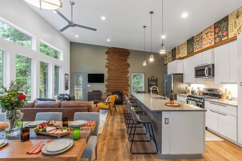 Open-concept living room, kitchen, and dining area with vaulted ceilings.