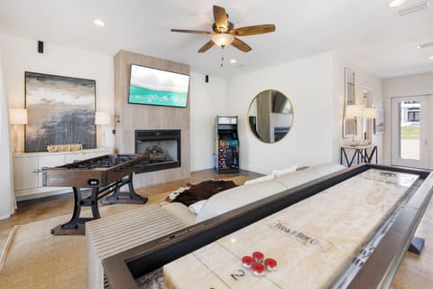 Unwind in your stylish game room featuring shuffleboard, foosball, fireplace, and modern entertainment for hours of fun.