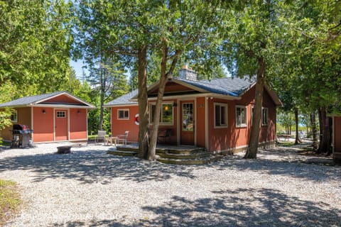 Bright lakeside cottage nestled under mature trees for shade and privacy.