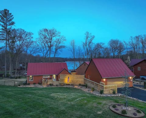 A stunning view of the home’s exterior surrounded by lush greenery, with the sparkling lake in the background creating a perfect tranquil retreat.