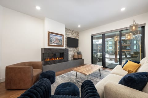 Sink into your cozy living room with crackling fireplace, plush seating, and warm lighting creating the perfect retreat.