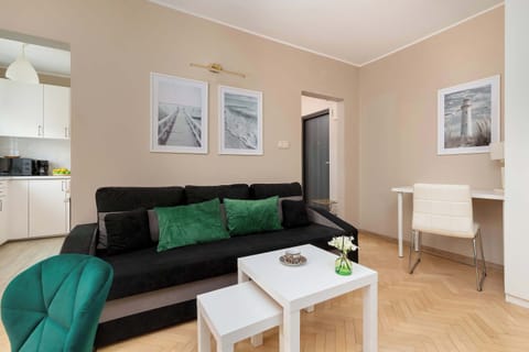 A living room with a dark sofa, a white coffee table, and a doorway leading toward another room.