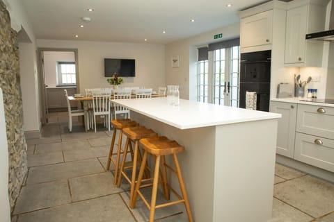 Kitchen breaksfast bar with stools, oven, dining area with table and chairs