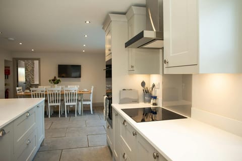 Kitchen with range of kitchen units, washing up sink, stove, dining table and chairs