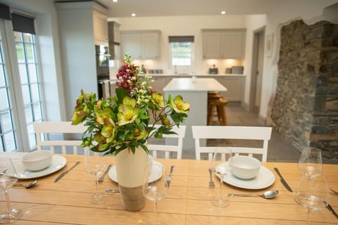 Dining table set for dinner with crockery and cutlery, vase of flowers