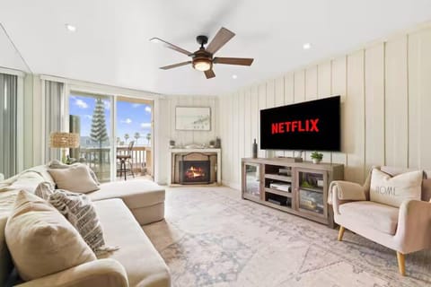 Spacious living area with Smart tv, indoor fireplace, dining table for 4, access to balcony with beach views