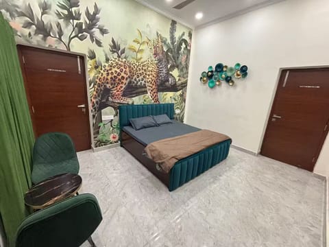 Stylish Delhi bedroom with luxury bed, jungle mural, AC & modern comfort
