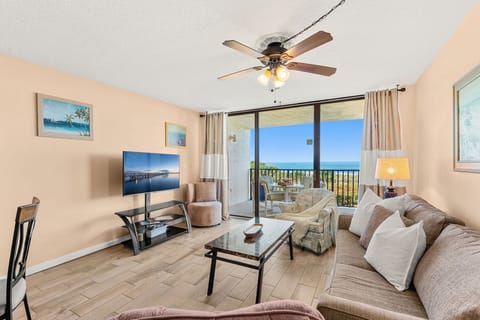Bright & airy living room with sliding glass doors that lead to direct oceanfront balcony