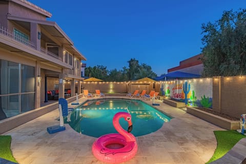 Spacious family pool with inflatables, basketball hoops, and ambient lighting