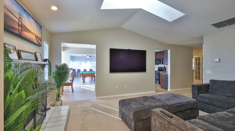 Living room with Lovesac, fireplace, skylight & 77" Sony Bravia OLED 4K TV