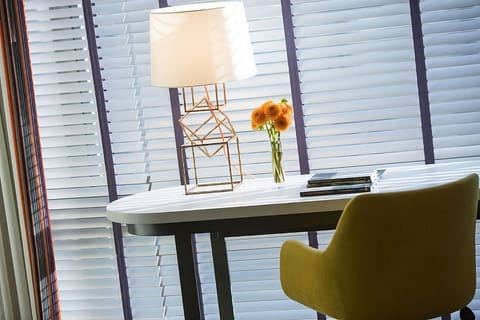Work comfortably at a bright desk beside sunny window shades.