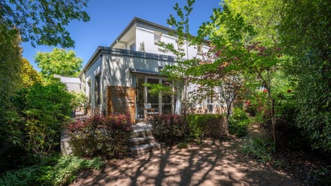 Charming townhouse entry surrounded by lush greenery.