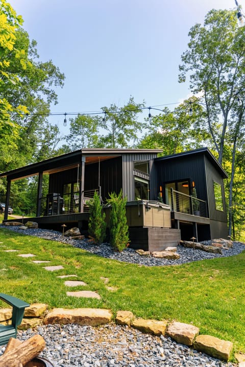 Modern woodland cabin with covered deck and peaceful hillside views