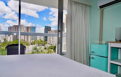 Room view of skyline with a mint fridge beside the bed