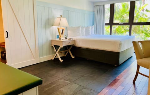 Bright room with king bed and floor to ceiling windows and trees