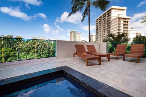 Wooden loungers set beside the pool with city views