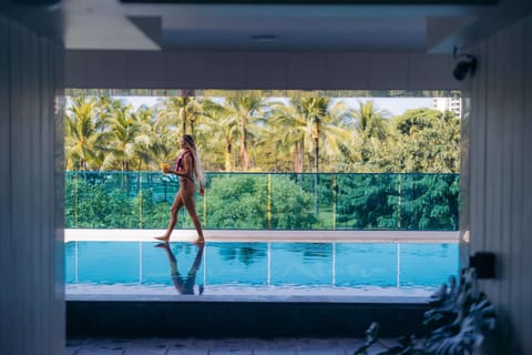 Guest walking by the pool with palm trees in the background