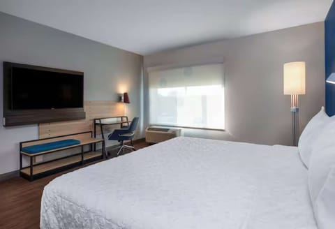 Room with a plush king bed, TV, and workspace