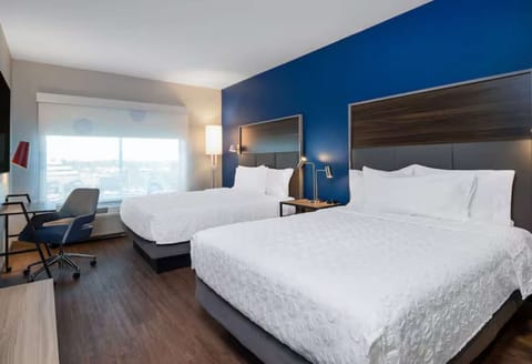 Room with two plush queen beds, a TV, and a workspace