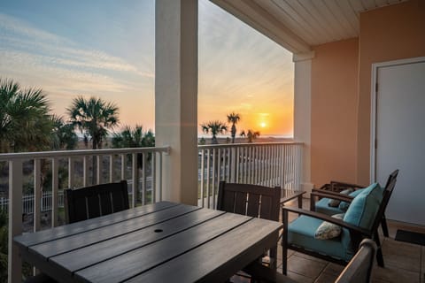 Watch stunning sunsets from your private balcony, where comfortable seating and tropical palm views create the perfect evening retreat.
