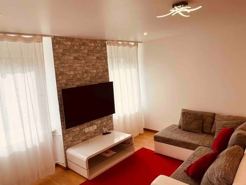 Salon bien agencé avec un canapé confortable et une télévision, offrant un espace convivial pour se détendre. Lm sud Conciergerie Montpellier