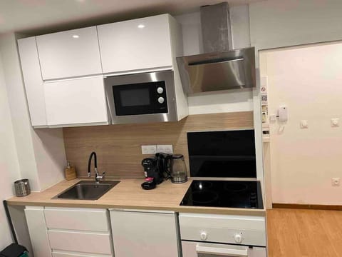 Cuisine ouverte entièrement équipée, offrant un espace fonctionnel et moderne.Lm sud conciergerie Montpellier