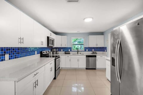 Enjoy a spacious kitchen with stainless steel appliances, white cabinetry, and a splash of blue. Ideal for Airbnb guests who love to cook and entertain.