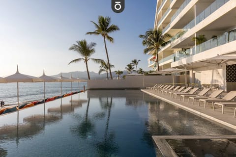 Ground floor beachside infinity pool with premium loungers and poufs