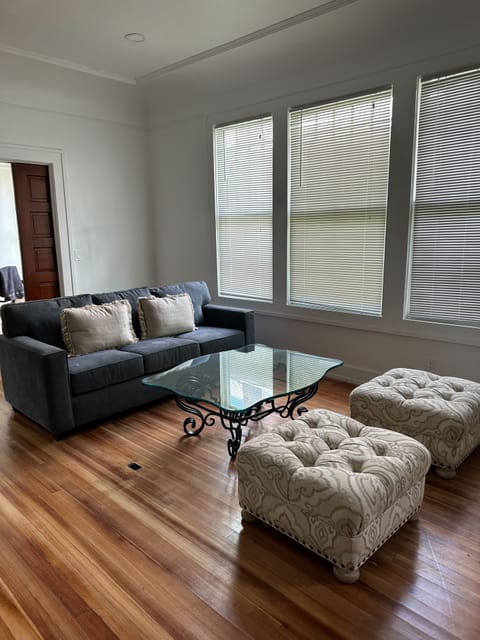 Living room with a couch, coffee table, and two ottomons