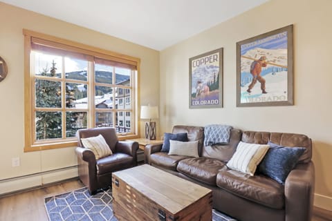 Relax in your comfortable living room with leather seating, mountain artwork, and large windows where you can unwind after your adventures.