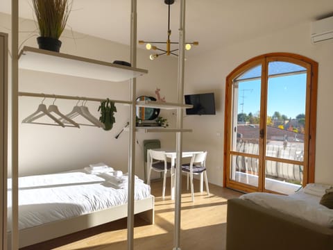 Living area of the modern apartment in Peschiera del Garda, with double bed, dining area, and large windows that fill the rooms with light. Perfect for couples or small groups of up to 3 people.