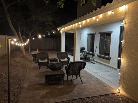 Illuminated backyard patio with furniture
